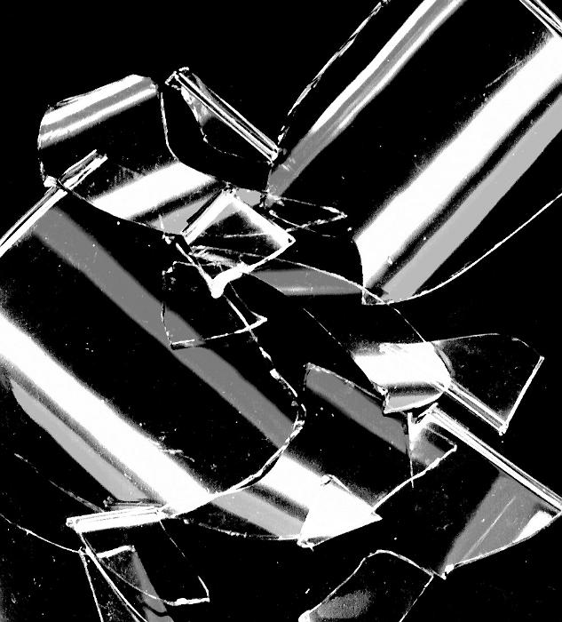 Free Stock Photo: Broken shards of glass reflecting light scattered in a random heap on a black background in a close up view