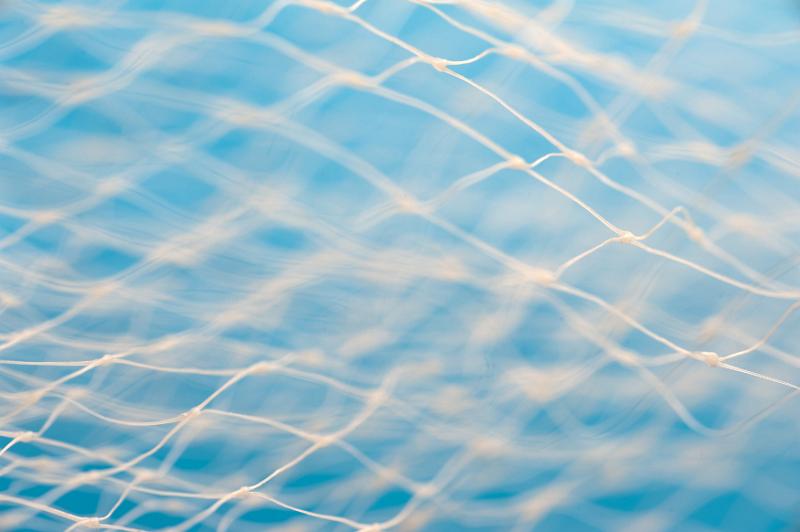 Free Stock Photo: Full frame of white net with center out of focus over blue water color background with copy space