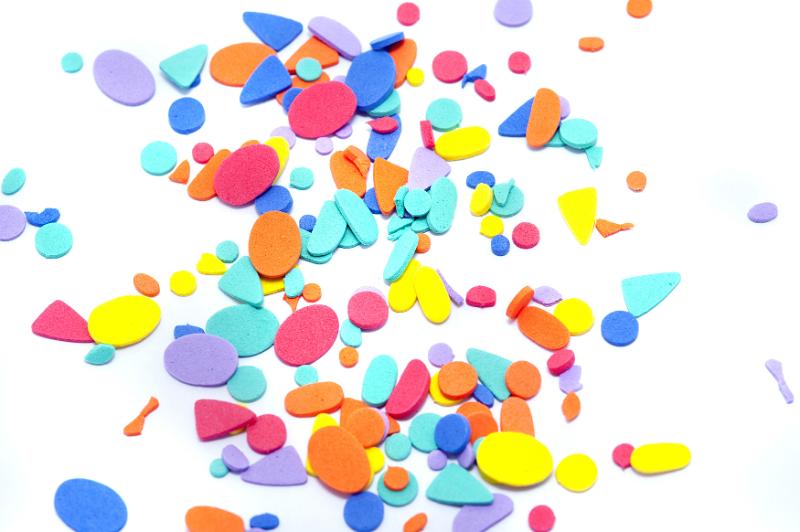 Free Stock Photo: Scattering of little blue, purple, red and yellow foam craft shapes over white background