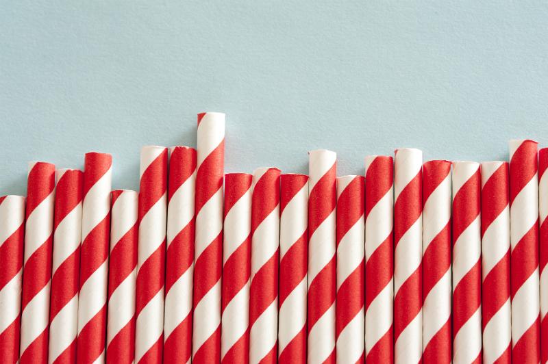 Free Stock Photo: Row of twenty diagonally red and white stripped straws against a light blue background