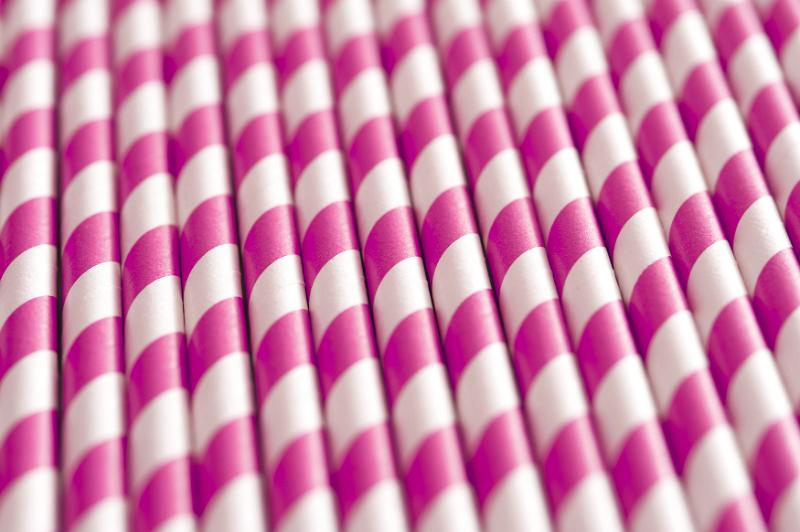 Free Stock Photo: Background pattern of colorful pink and white spiral paper drinking straws viewed in a pile at an oblique angle, full frame