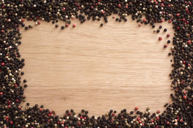 Free Stock Photo: Peppercorn spice frame on wood with assorted black, red and white whole dried peppercorns for food themed concepts with central copy space