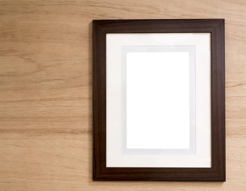 Free Stock Photo: Empty wooden frame with mount card hanging on a wood panelled wall with copy space in the center for your artwork