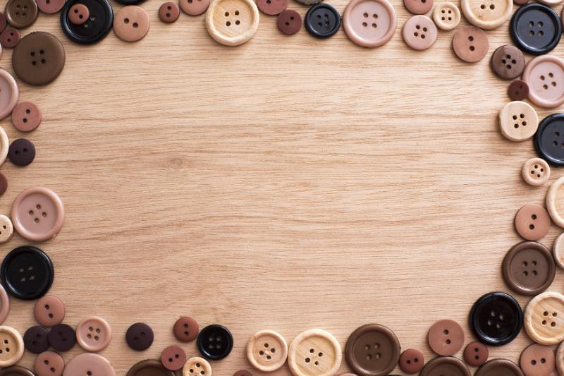 Free Stock Photo: Fashion frame of assorted brown toned buttons on a wooden background with copy space viewed from above