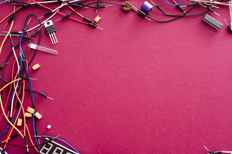 Free Stock Photo: Electronic corner border with assorted connectors and colorful wires on a textured deep crimson background with copy space