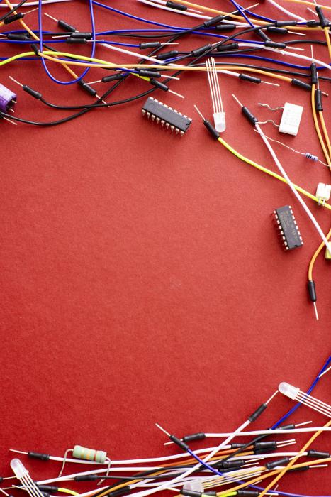 Free Stock Photo: Electronics wires border on red with multiple jumbled multicolored plastic covered wiring and connectors around central copy space