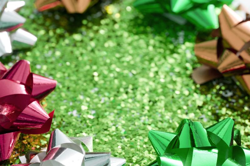 Free Stock Photo: Green glitter background with bow frame of metallic shiny spiky ribbon bows for a festive party celebration or Christmas greeting