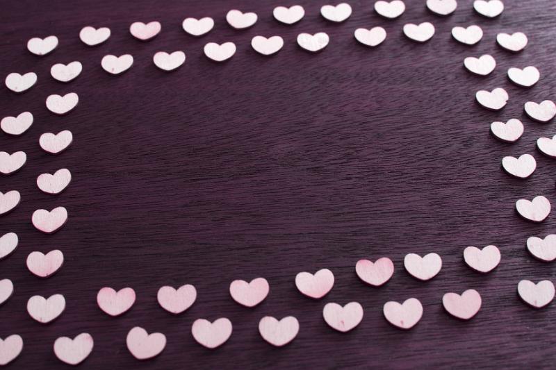 Free Stock Photo: Double square hearts frame with two rows of small white hearts on dark textured wood with central copy space
