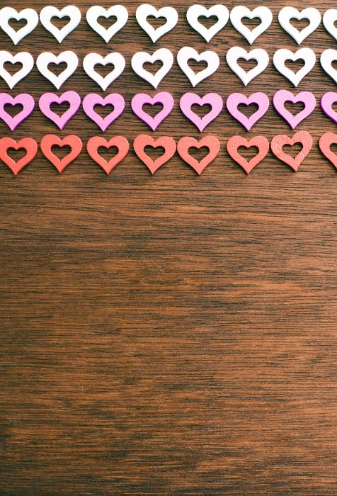 Free Stock Photo: Colorful rows of cut out modern shaped hearts on wood with copy space below for your romantic or love themed concepts