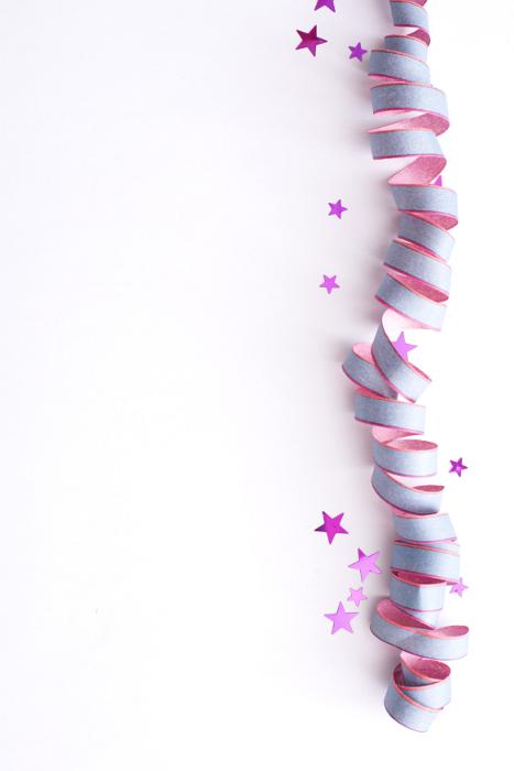 Free Stock Photo: Colorful party sidebar with a coiled pink streamer and stars over a white background for your celebratory wishes or invitation