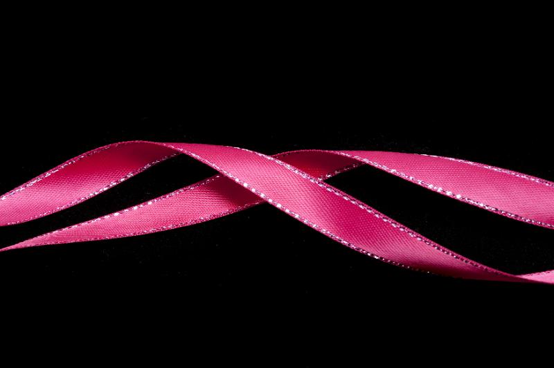 Free Stock Photo: Twirled pink ribbon festive border on a dark background with copy space above and below for your greeting