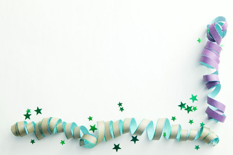 Free Stock Photo: Streamers corner border party background with spiral coiled green and purple ribbons and scattered stars over white with copy space for your seasonal holiday or birthday greeting