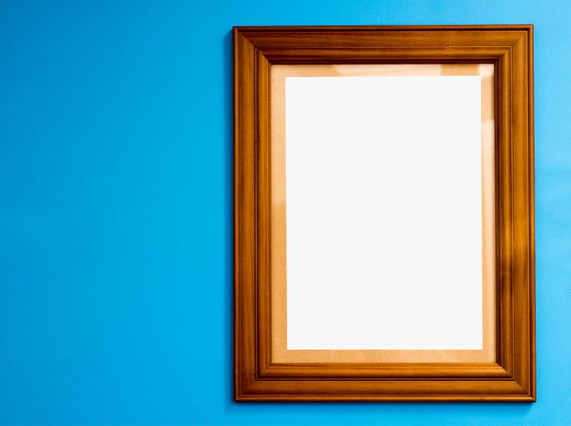 Free Stock Photo: Empty wooden frame for your artwork or photo on a blue background with copy space alongside