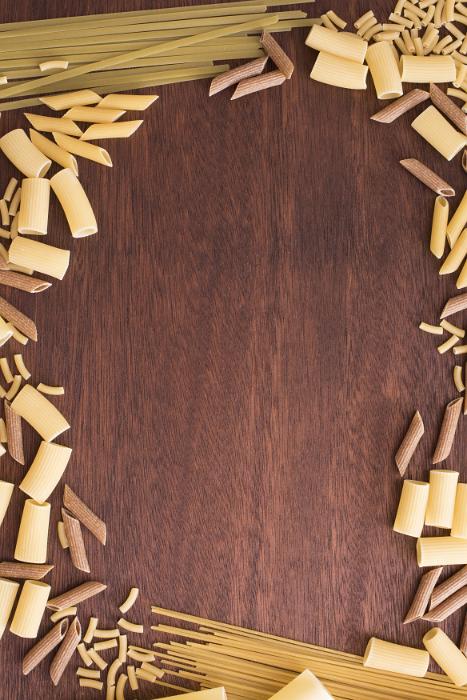 Free Stock Photo: Assorted dried Italian pasta forming a decorative frame over a wooden background with central copy space
