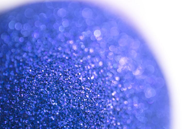 Free Stock Photo: Decorative blue glitter ball or Christmas bauble viewed close up with shallow DOF over white with copy space