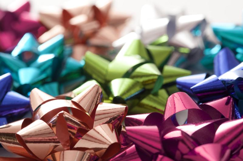 Free Stock Photo: Background of colorful shiny decorative bows for gift wrapping ad packaging with focus to a pink and coppery one in the foreground