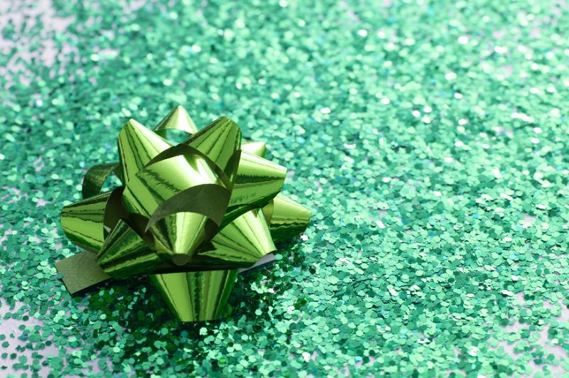 Free Stock Photo: Festive green glitter background with a decorative bow of shiny green ribbon and copy space for your greeting or text