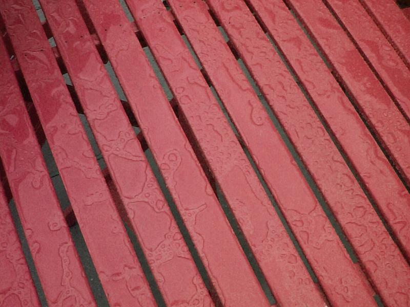 Free Stock Photo: Top of red colored wooden or plastic table with water drops from rainfall on surface