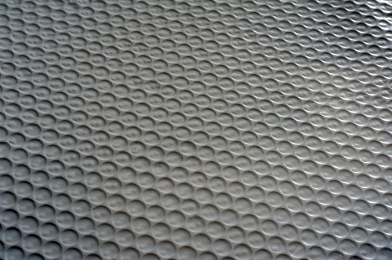 Free Stock Photo: Extreme close up view of black plastic mat with rows of circles pressed into it