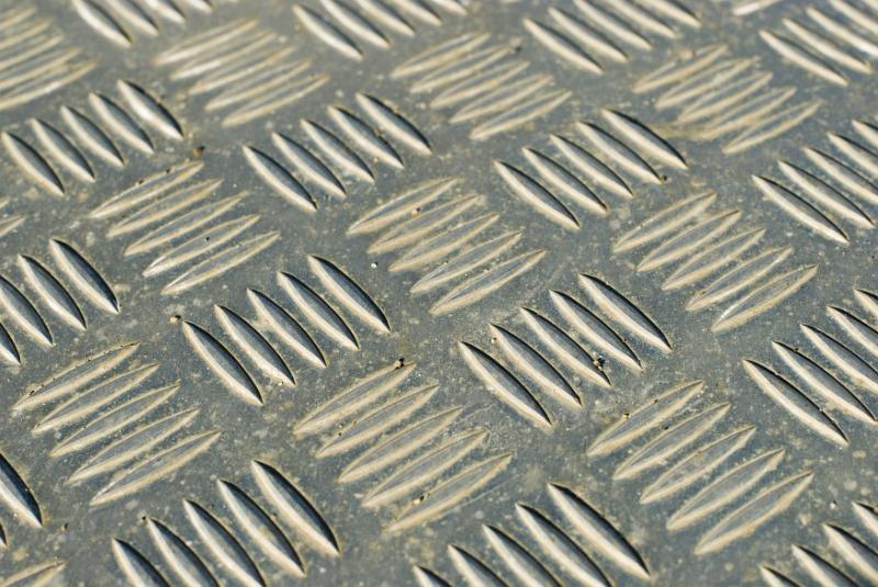 Free Stock Photo: Checker plate ridged metal plate with a pattern of alternating blocks of raised lines in a diagonal full frame view