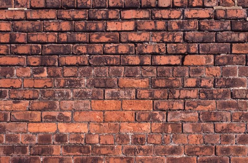 Free Stock Photo: Old weathered brick wall background texture with discolored red bricks in parallel rows showing architectural detail
