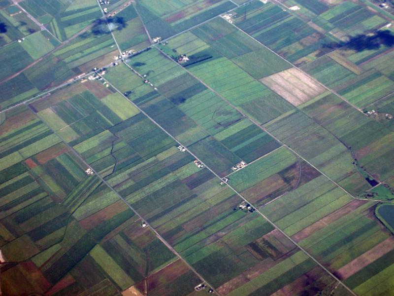 Free Stock Photo: Aerial view of cultivated farmland in flat open countryside with a scattering of farm houses