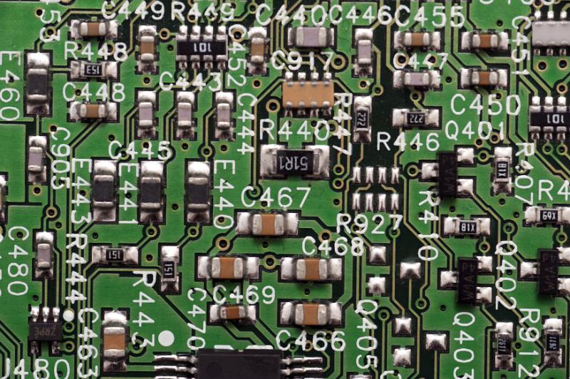 Free Stock Photo: Close up of electrical components on green circuit board labeled with numbers and letters
