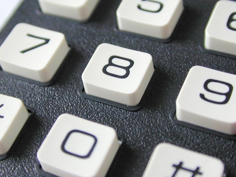 Free Stock Photo: Macro shot of the white numerical keys or buttons on a keypad with a textured dark grey surface