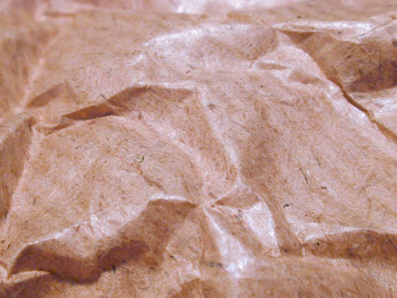 Free Stock Photo: Extreme close up of crumpled waxy brown paper with highlights from overhead light source