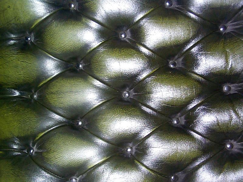 Free Stock Photo: Tightly cropped close up on dark green sofa back cushion with leather type upholstery