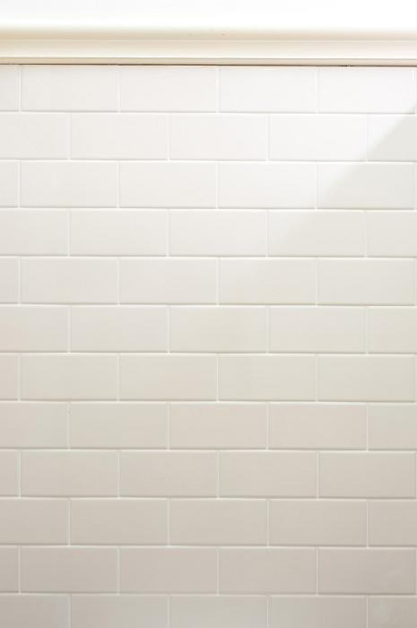 Free Stock Photo: Tall clean white tile or brick wall background with subtle shadow and copy space