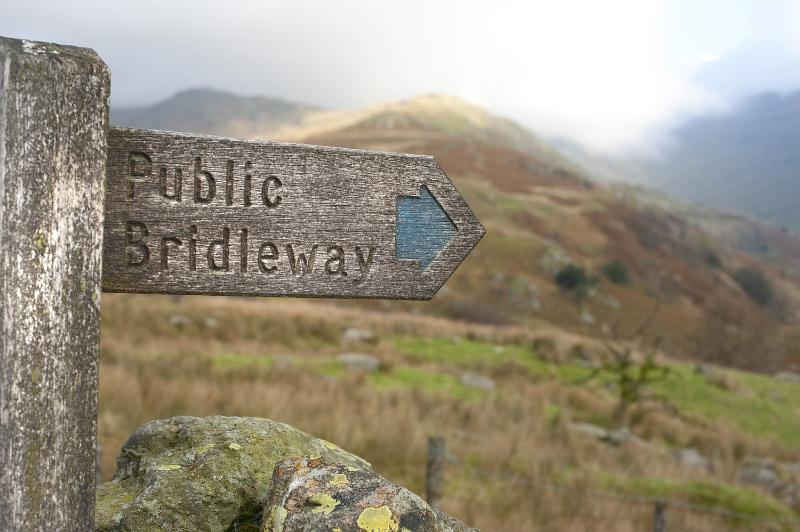 Free Stock Photo: Rustic wooden arrow showing the right direction towards the public bridleway, in a wild mountainous area