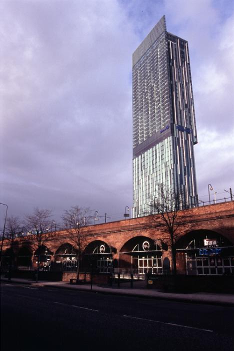 Free Stock Photo: Architecture in central Manchester with a tall modern skyscraper towering above a historic arched railways bridges
