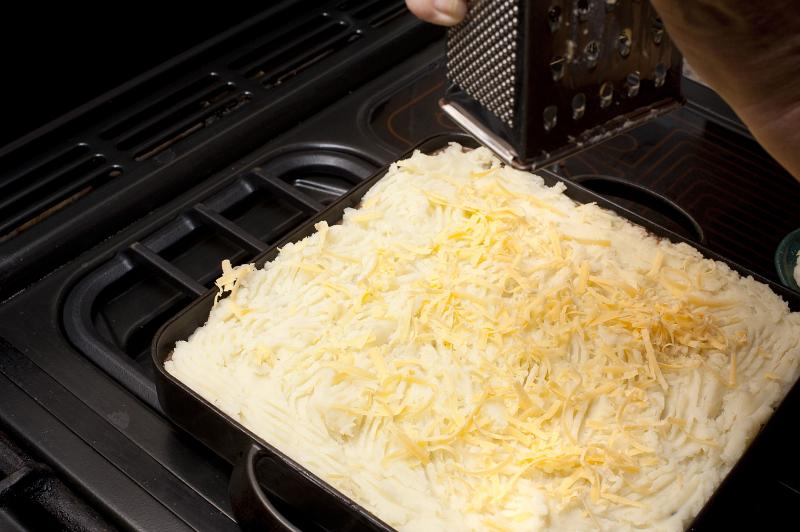 Free Stock Photo: Cheese topped cottage pie or shepherds pie with minced meat with a potato crust in an oven dish ready to be baked or grilled