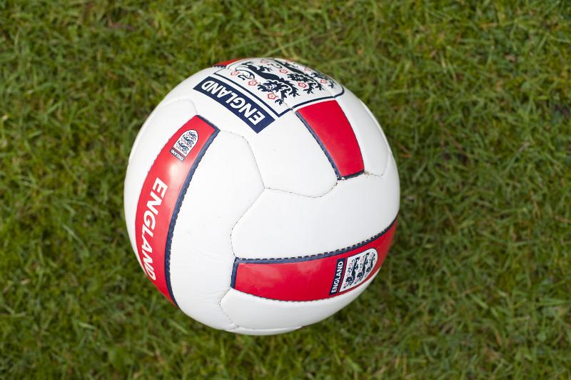 Free Stock Photo: England soccer ball of football with the England emblem on the leather on a green grass background in a sport championship concept