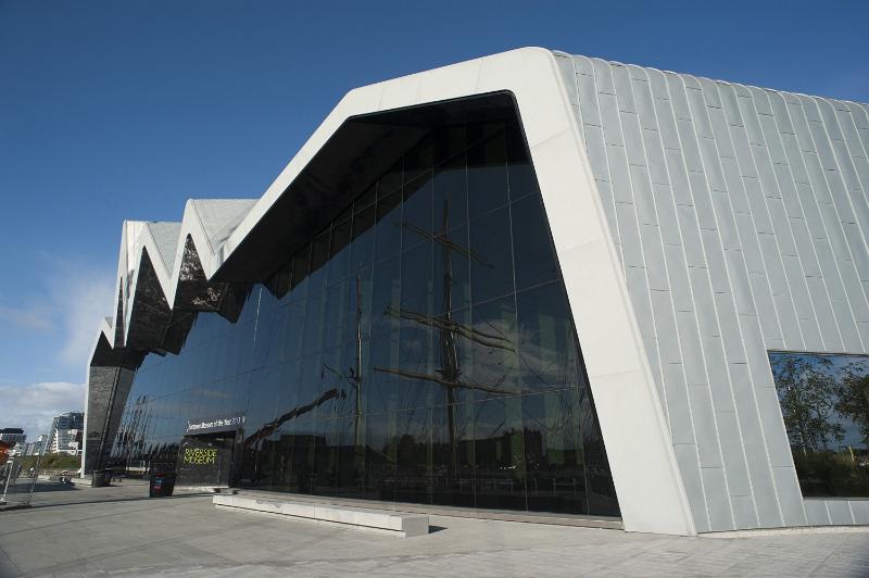 Free Stock Photo: Exterior of the Riverside Museum in Glasgow with its modern architecture housing transport exhibits and a tall ship in the harbour reflected in the window