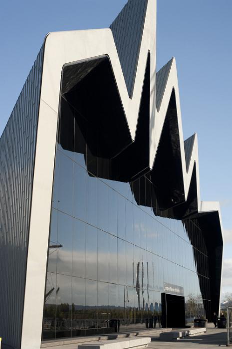 Free Stock Photo: Modern exterior facade of the Glasgow Riverside Museum with its distinctive zigzag design above a large glass window reflecting a tall ship exhibited in the harbour
