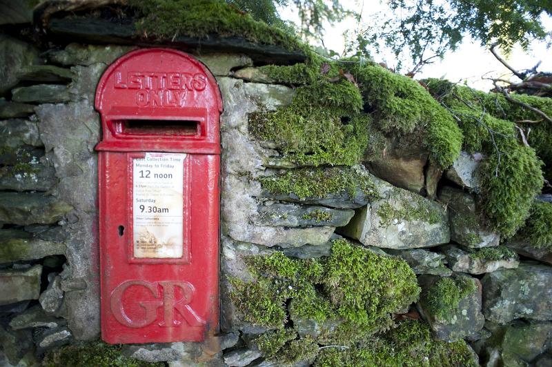 Free Stock Photo: iconic red British post box set into a rural stone wall for the collection of letters and mail for further distribution through the postal services