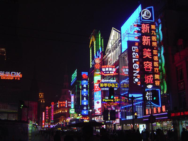Free Stock Photo: Commercial street in China with bright neon advertising lights covering the walls of the high rise buildings in a colorful night scene