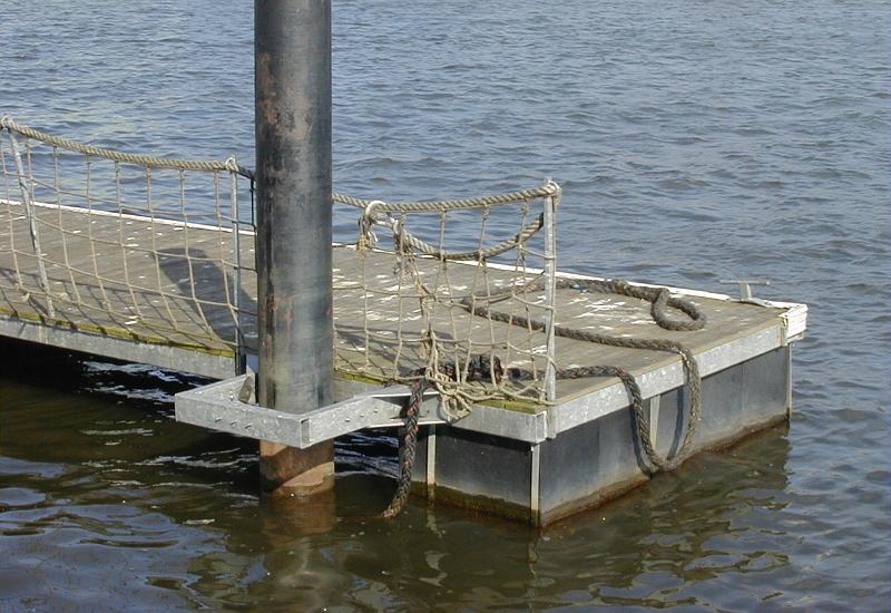 Free Stock Photo: Large floating pontoon jetty or pier showing the end pole support and mooring ropes for boats