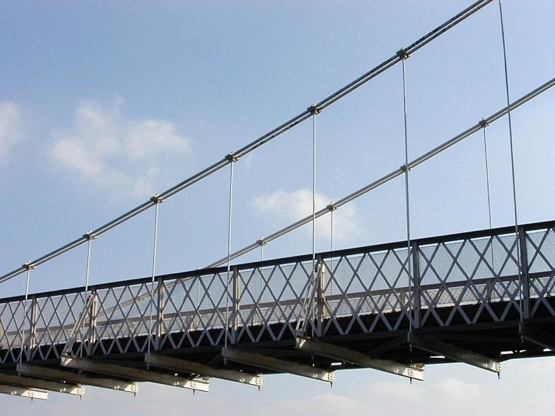 Free Stock Photo: Suspension bridge deck in close-up from low angle against blue sky