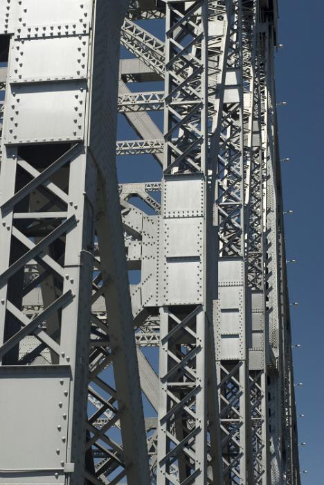 Free Stock Photo: Detail of tall steel bridge trusses against a blue sky in an engineering and architectural concept