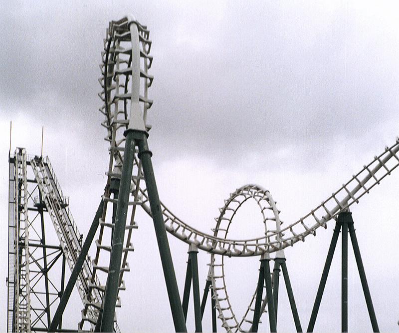 Free Stock Photo: Amusement park roller coaster ride against cloudy sky showing the track doing loop the loops with sharp descents