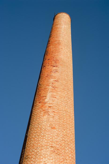 Free Stock Photo: Old red brick industrial chimney viewed from below rising against a blue sky