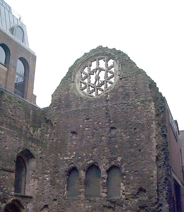 Free Stock Photo: Remnants of a rose window in an old ruined historic stone church with boarded up windows under a cloudy sky
