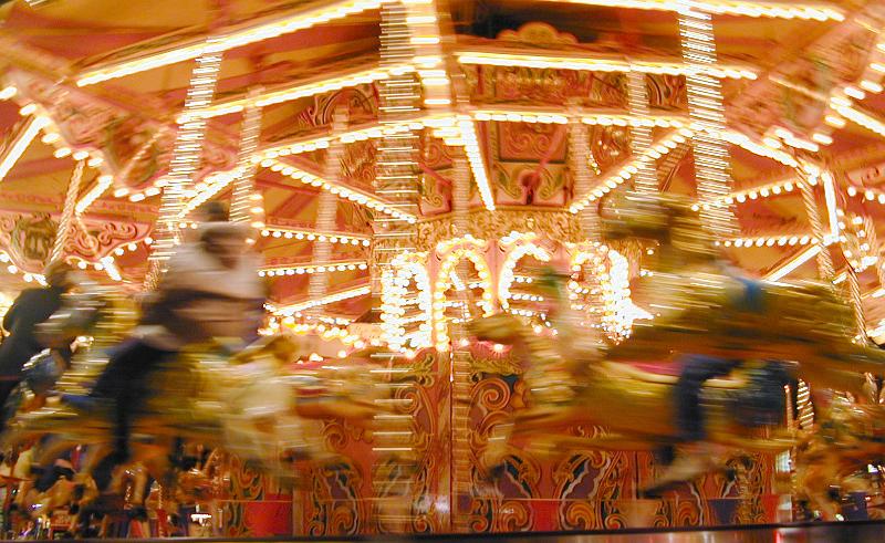 Free Stock Photo: Motion blur view of the animals of a carousel or merry-go-round at an amusement park spinning past the lens