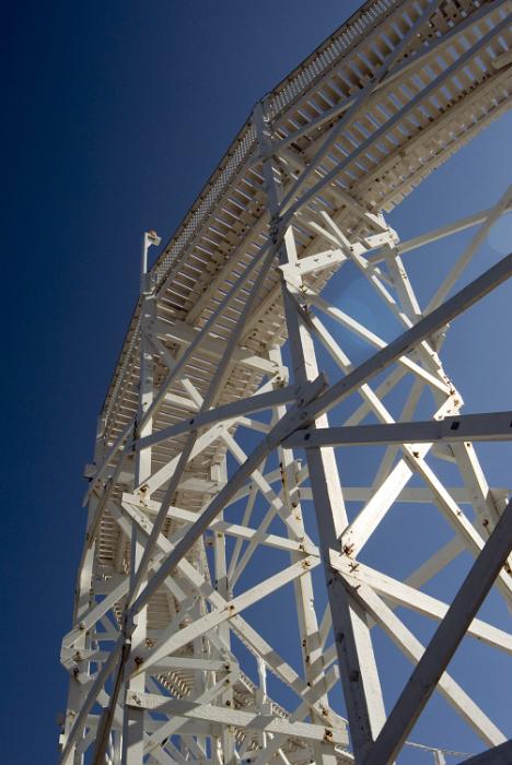 Free Stock Photo: Looking up at the structure of a Big Dipper rollercoaster at an amusement park with a view up to the track against a blue sky
