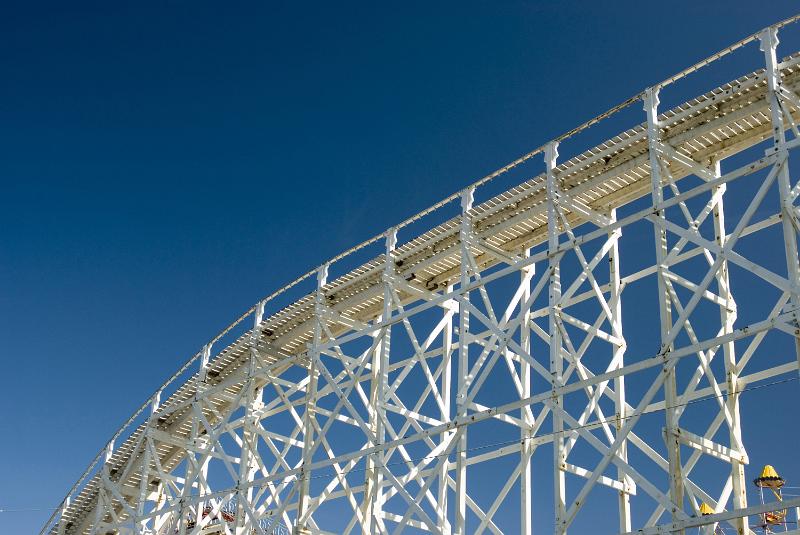 Free Stock Photo: A low angle of an overhead roller coaster track and clear, blue sky.