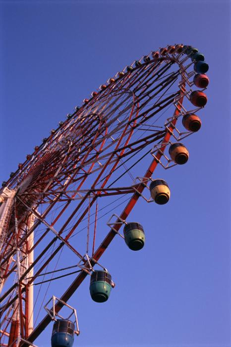 Free Stock Photo: Looking up at the rim and gondolas of a Big Wheel at an amusement park or fairground against a blue sky
