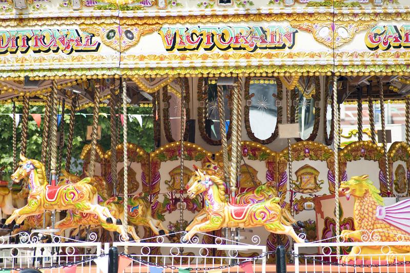Free Stock Photo: An empty amusement park ride with gold, carousel horses.